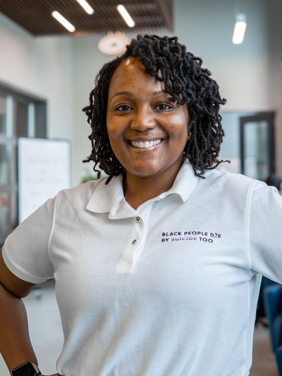 Woman smiling for a headshot in a gray collar shirt.