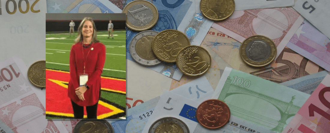 Headshot of Lorenzetti in front of international monies