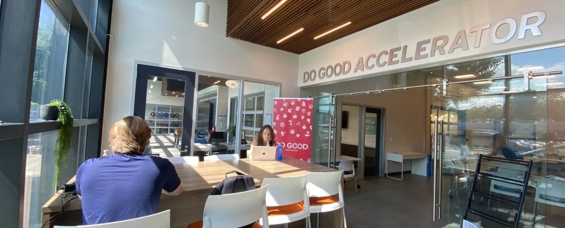 Two students sitting in a well lit room at a table with Do Good Accelerator 
