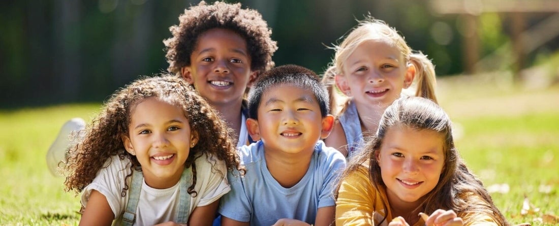 image of kids laying outside in a field of grass
