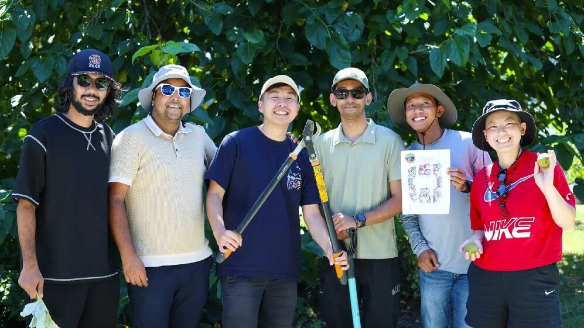 Group of men with hats on standing in front of trees