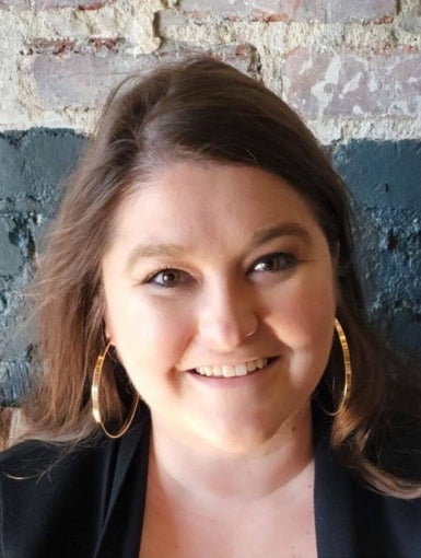 a white woman with light brown hair and blazer